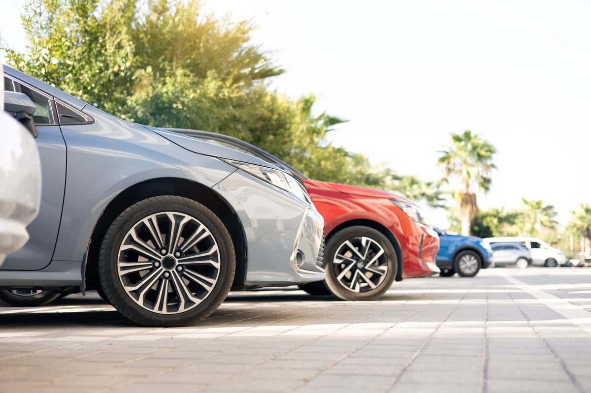 A row of new vehicles parked together waiting to be rented